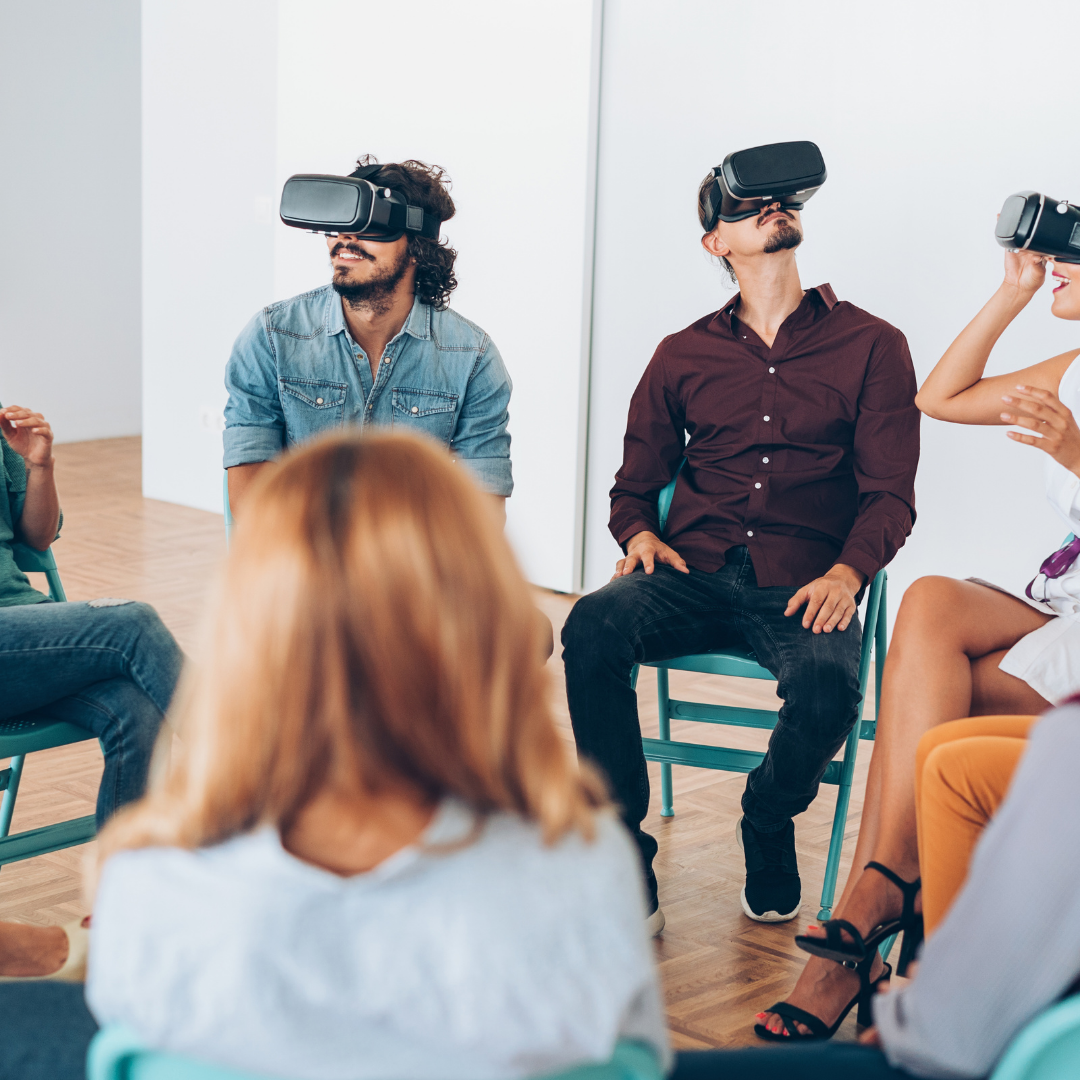 a group of people sitting in a circle with virtual reality head sets looking around